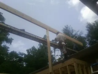 Carpenter setting a ridge beam over a new addition frame — Ice Dam Removal by Roofing Brothers in West Middlesex