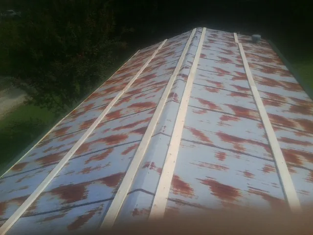 Rusted metal roof panels with new wood purlins before replacement — Storm Damage Roof Repair in West Middlesex by Roofing Brothers