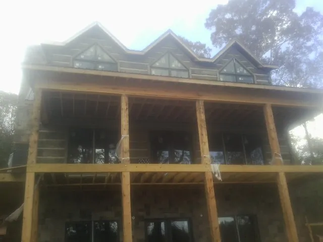 Dormers and porch framing on a large log home under construction — Roof Coating work by our crew in West Middlesex